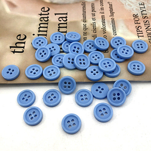 10mm light blue round buttons with four holes, scattered across the card surface