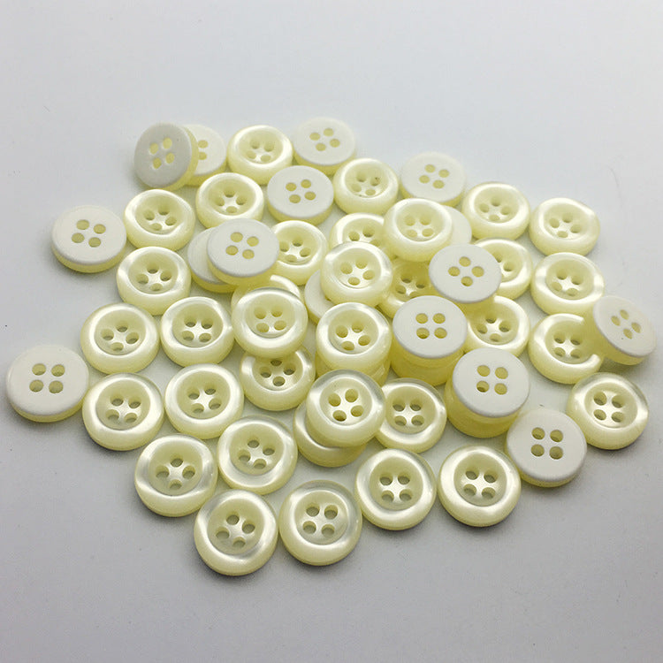 Assorted beige round 4-hole buttons, flat front view, kids sweater/jacket supplies