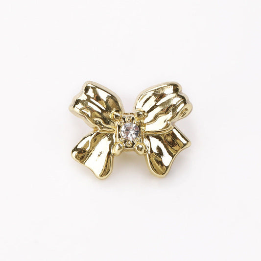 Light gold-toned crystal bow button with raised metal butterfly design