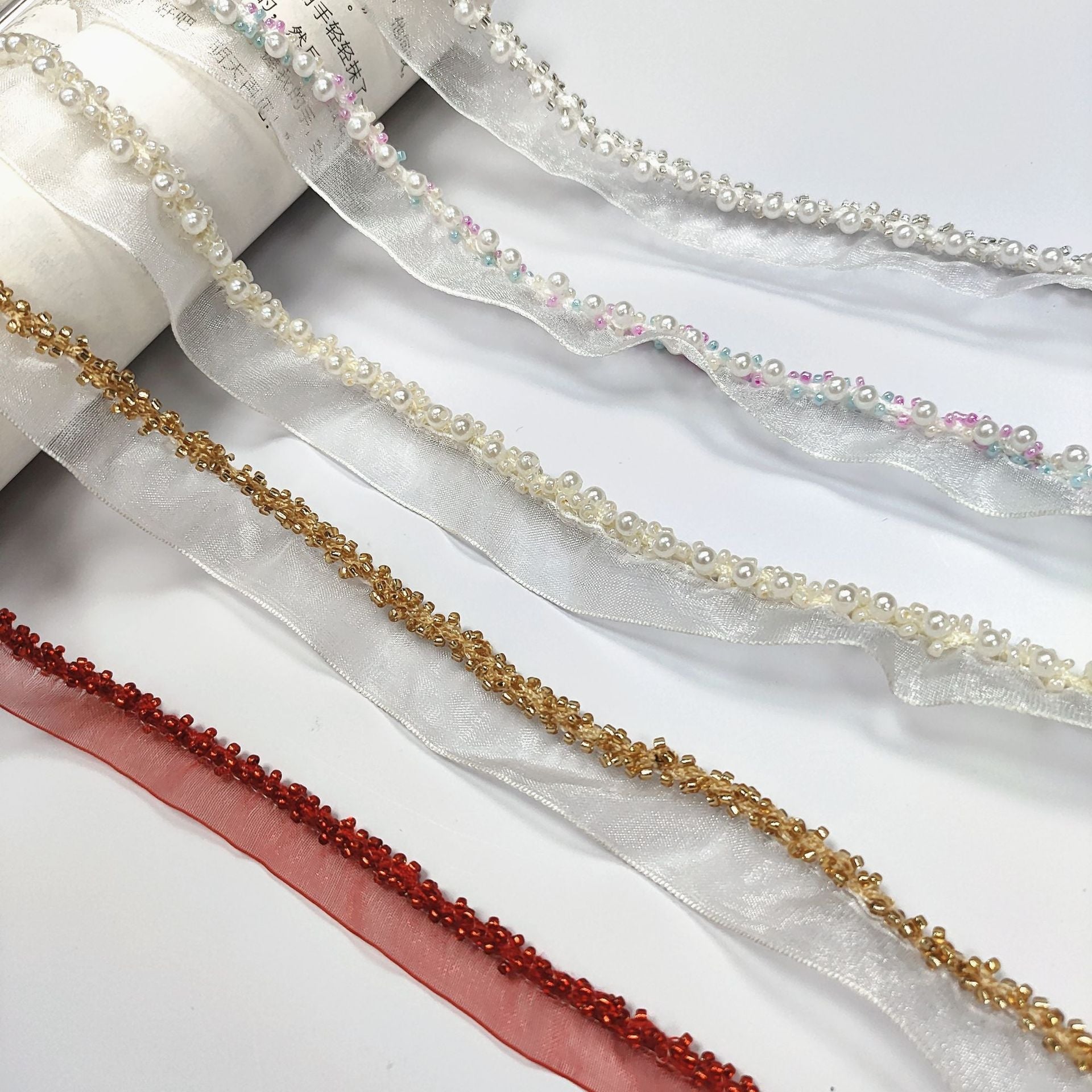 Pearl-trimmed crystal lace ribbon—white, gold, red and iridescent bead trims