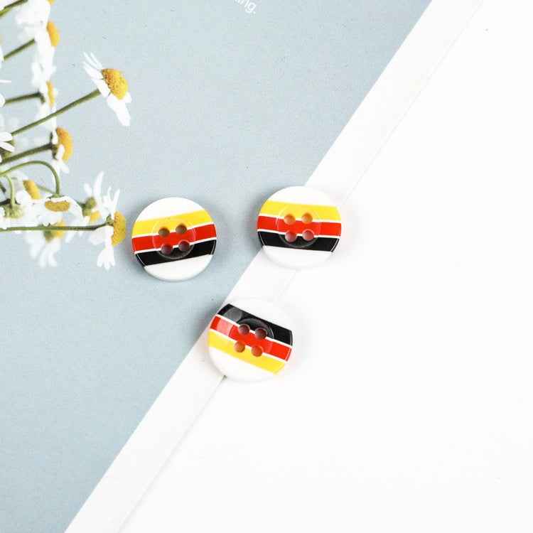 Ronde knoop met vier gaten, gestreept gelb/rood/ schwarz en weißer Hintergrund