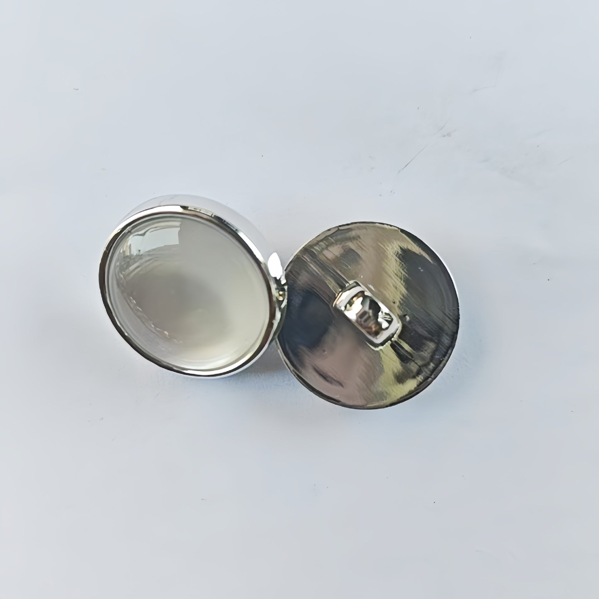 Pair of round pearlized cat’s eye shirt shank buttons with metallic gold backing