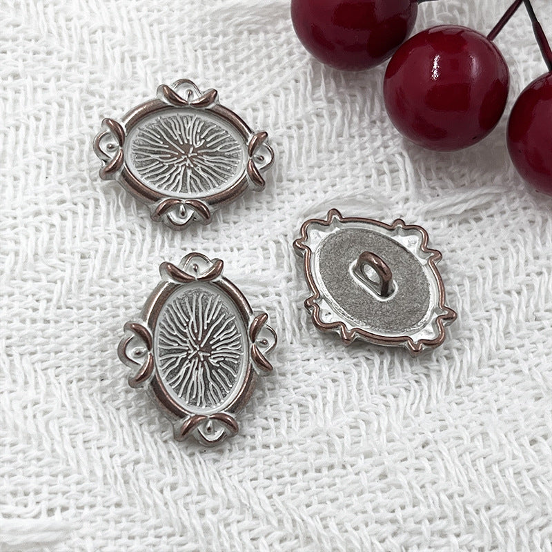 Silver oval metal shank buttons with engraved floral design; front view and back view shown