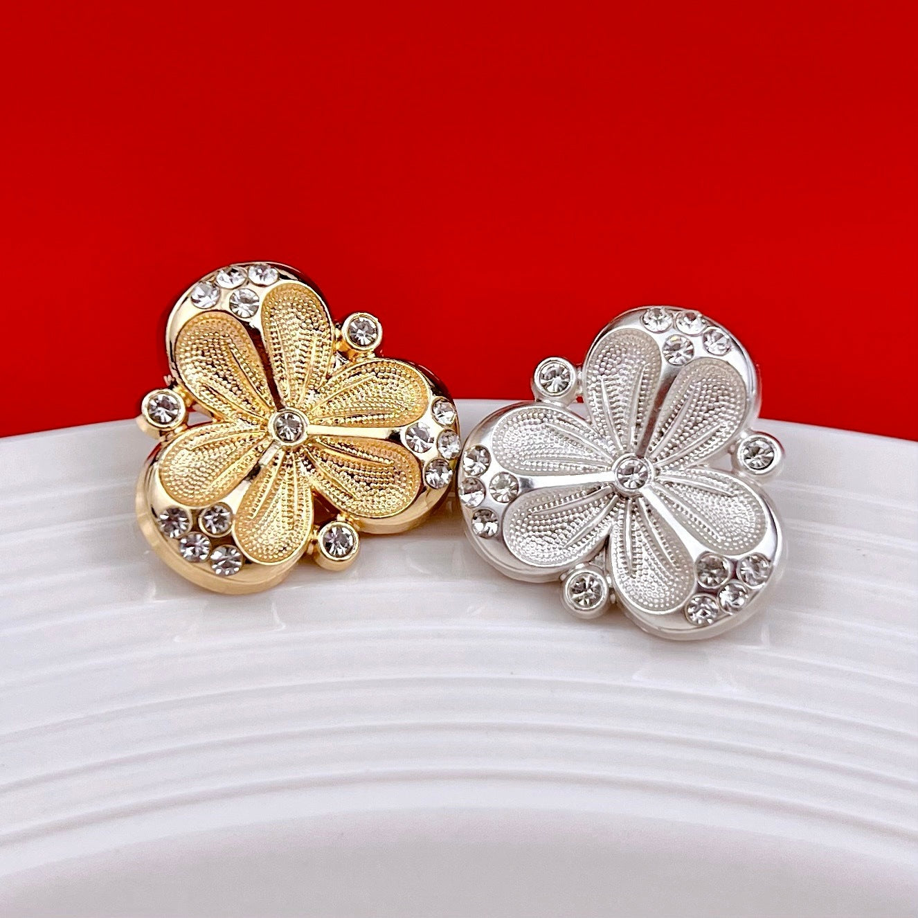 Three-petal flower metal shank buttons in gold and silver, crystal-studded petals