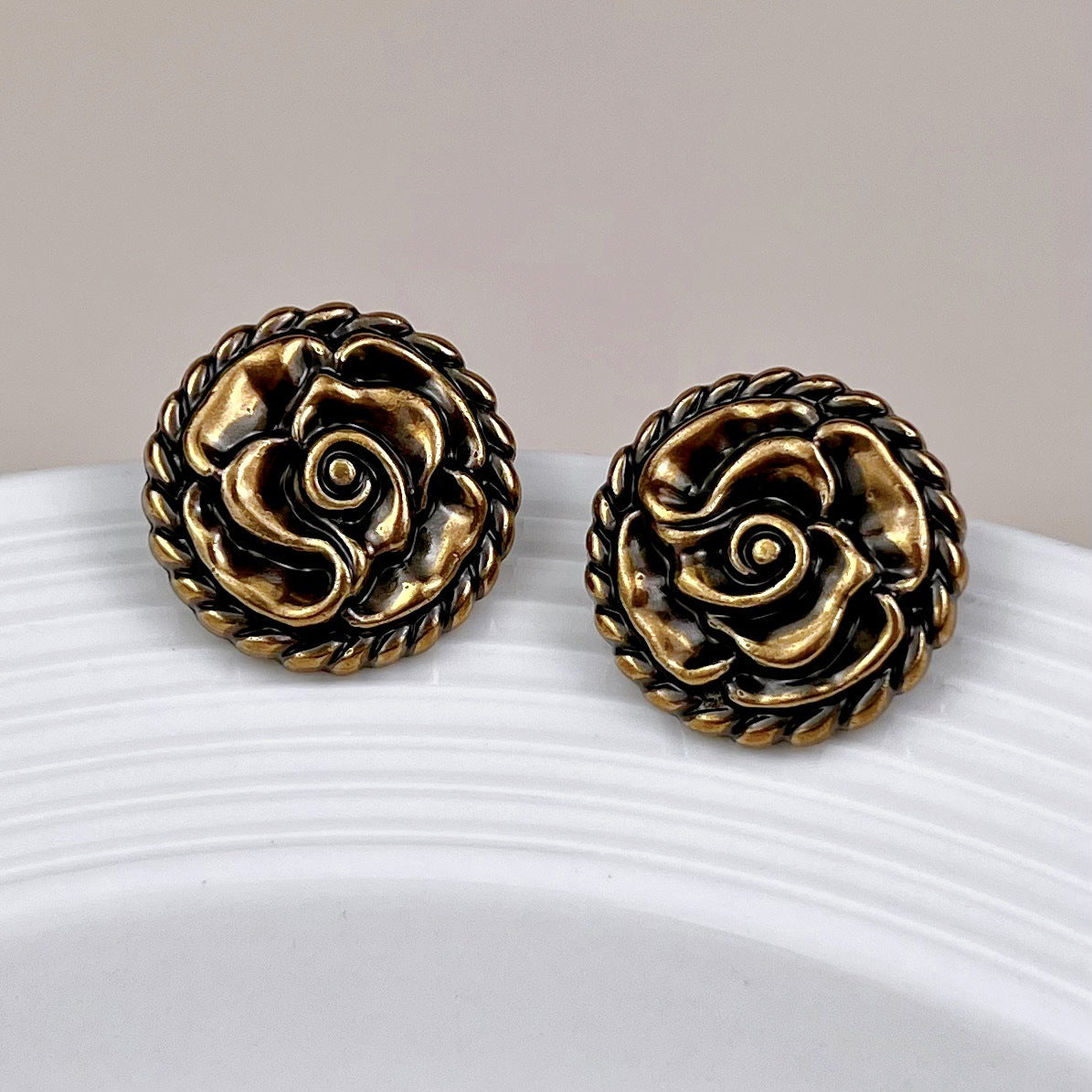 Pair of rose metal shank buttons with vintage gold finish and black center details