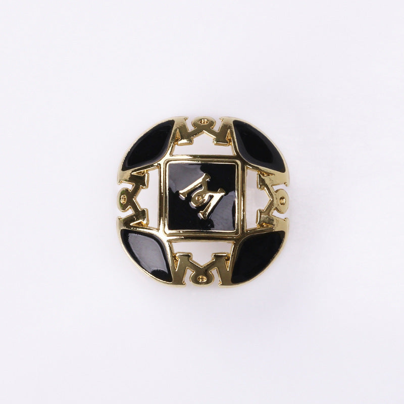 Letter M button, black enamel with white insets, gold metal 2-hole shank
