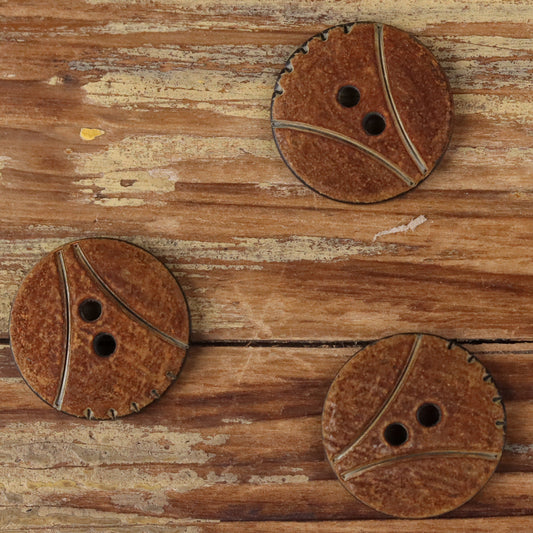 Round 2-hole horn buttons with scorched finish, three buttons shown on wood
