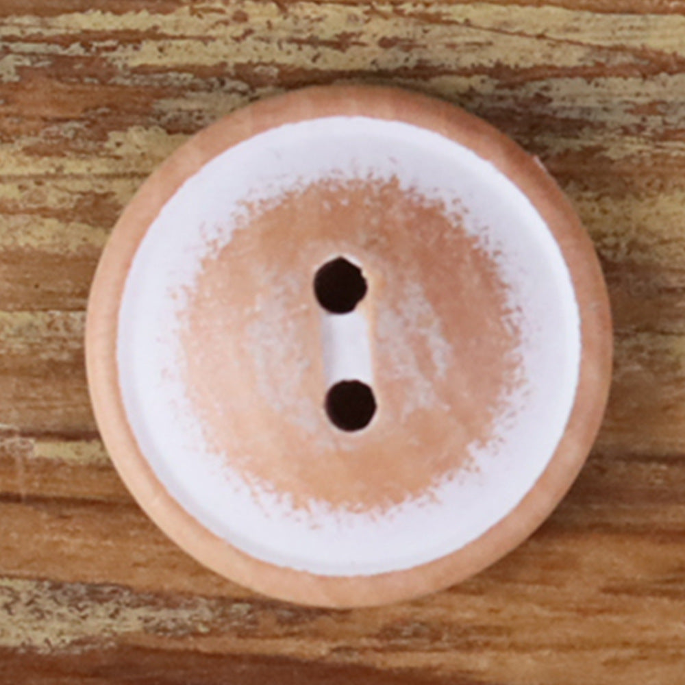 Round white wood 2-hole button with two dark holes, close-up