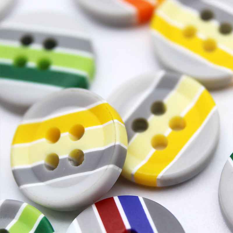 Round resin buttons with yellow and white stripes and four holes; set among other striped colors
