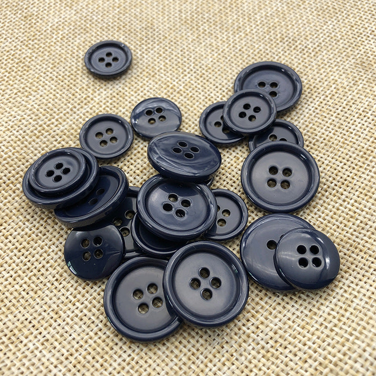 Assorted navy round resin buttons with 4 holes, mixed sizes shown on woven background