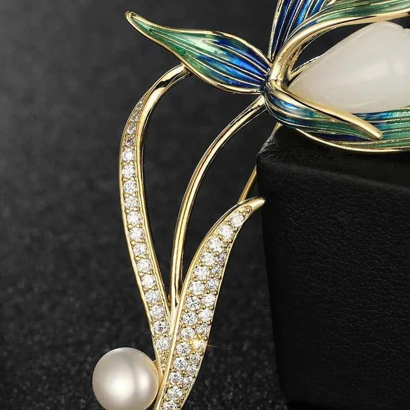 Close-up magnolia brooch pin: gold-tone curved prongs with crystal accents and pearl