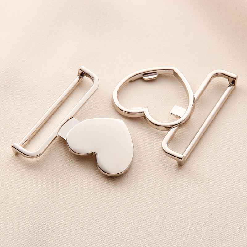 Gold-tone heart-shaped belt buckle clasp with curved ring and side bar