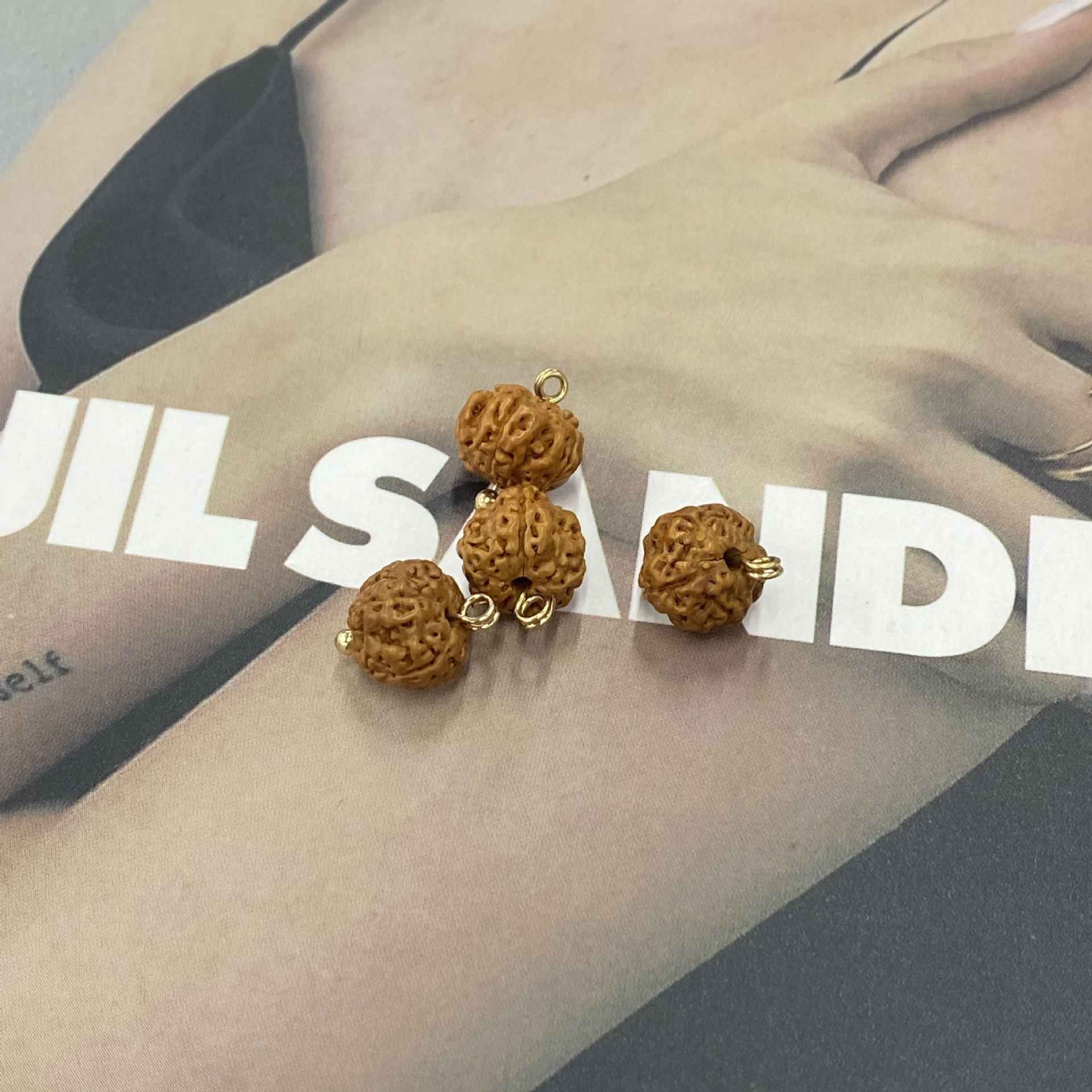 Multiple 9mm irregular brown textured fruit-seed shell buttons with gold metal loops