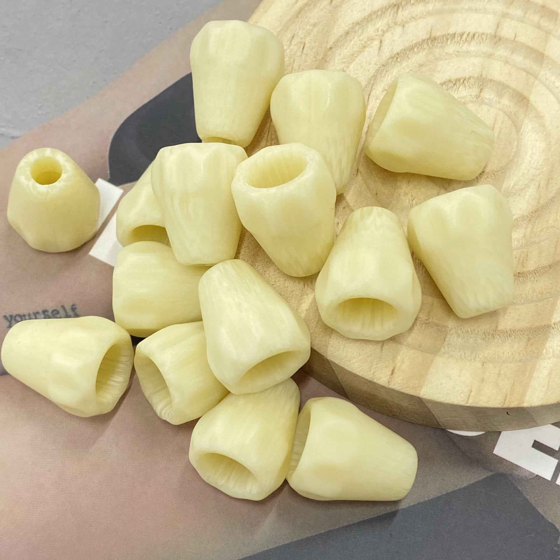 Light yellow resin single-hole cord end stopper, translucent bell shape