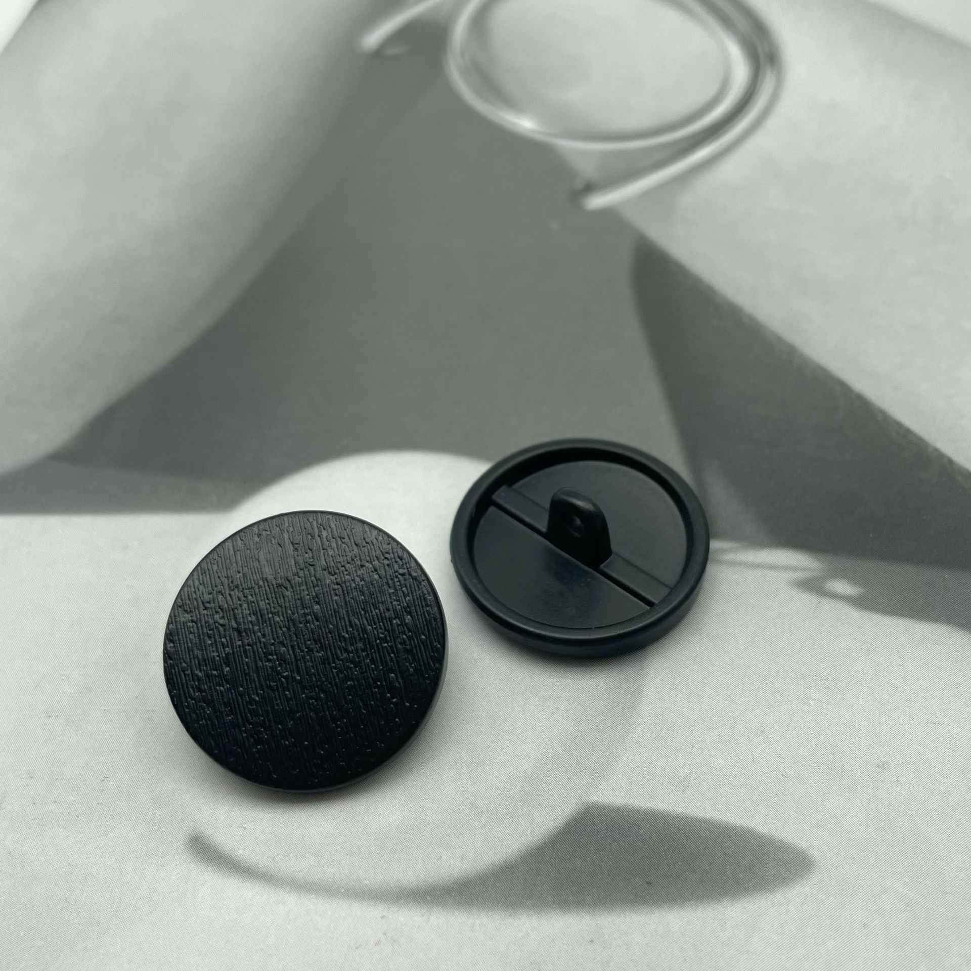1-inch round matte metal shank button, black with shank and back view