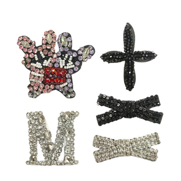 Strass-Applikationen: bunter Stern, schwarze Schleife, silberner Buchstabe N, silberne Schleife