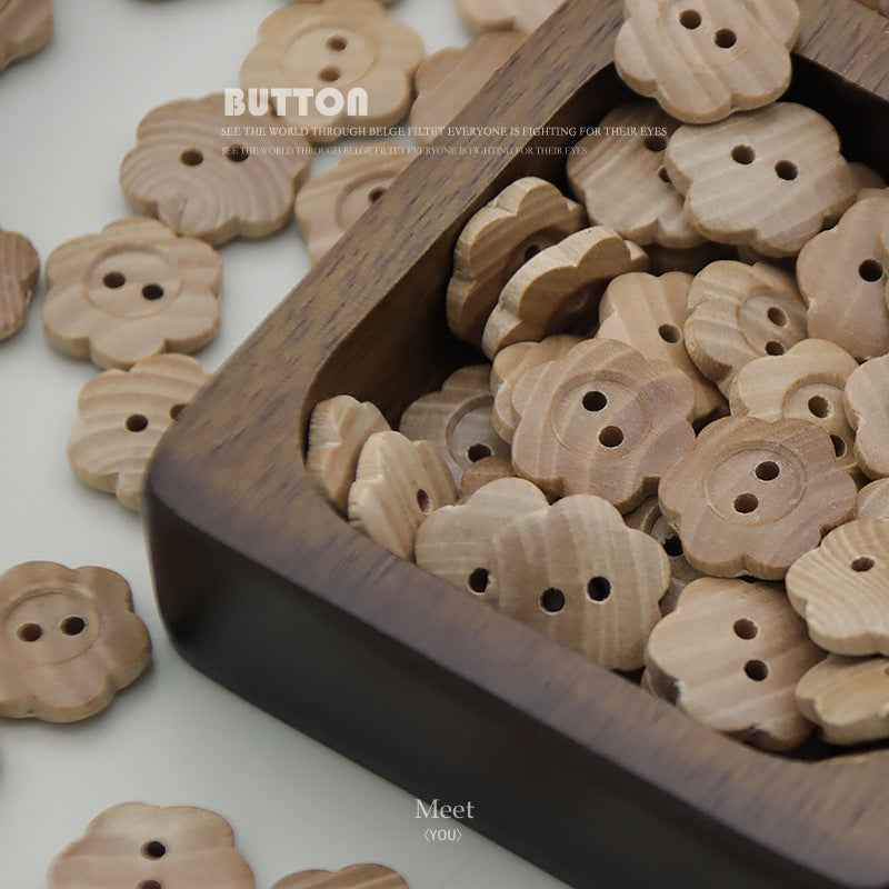Natural wood 2-hole flower buttons in a tray, light tan, dark holes