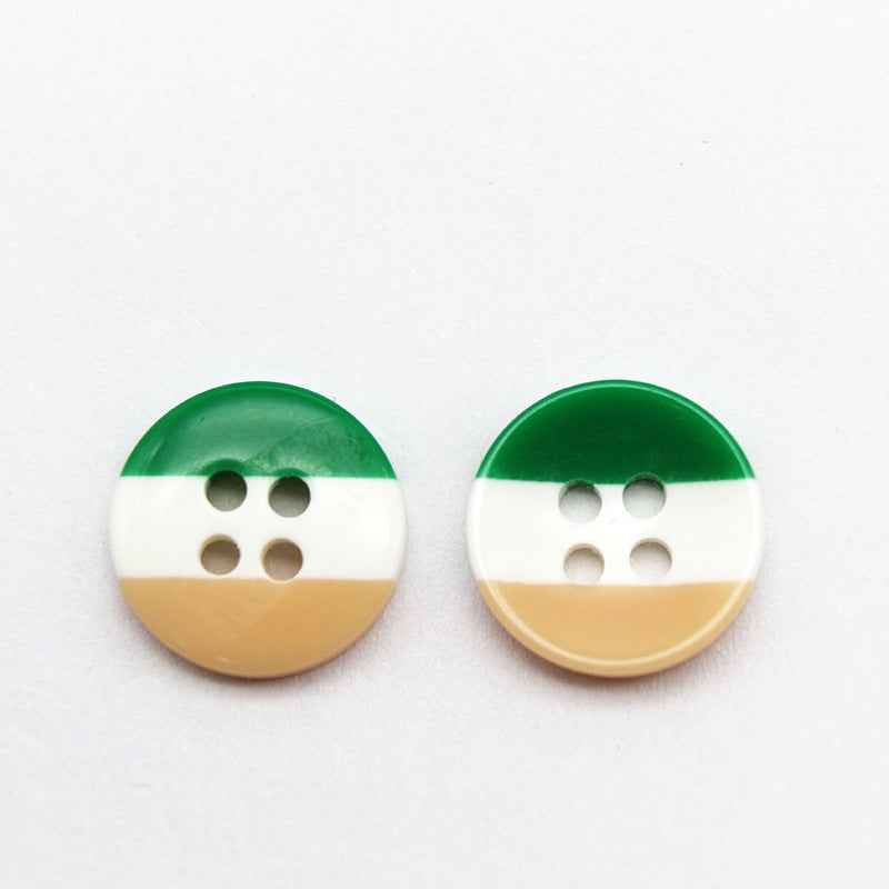 Round resin button with green top, white middle, and tan bottom stripe; four holes.