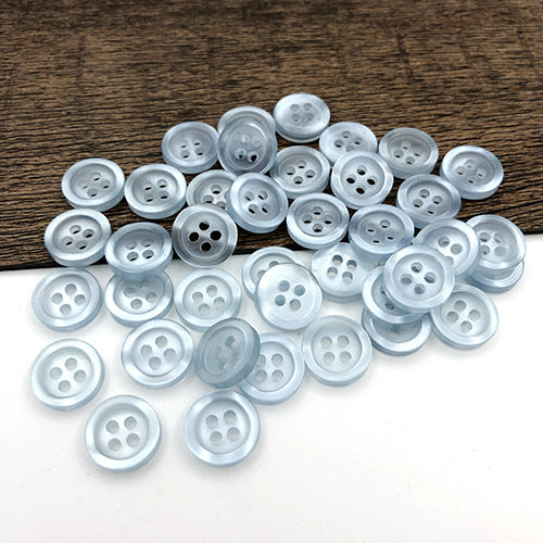 Very light blue round 4-hole shirt buttons, round faces with four holes