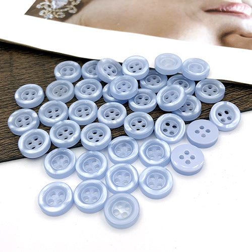 Powder blue round 4-hole shirt buttons, many buttons grouped together