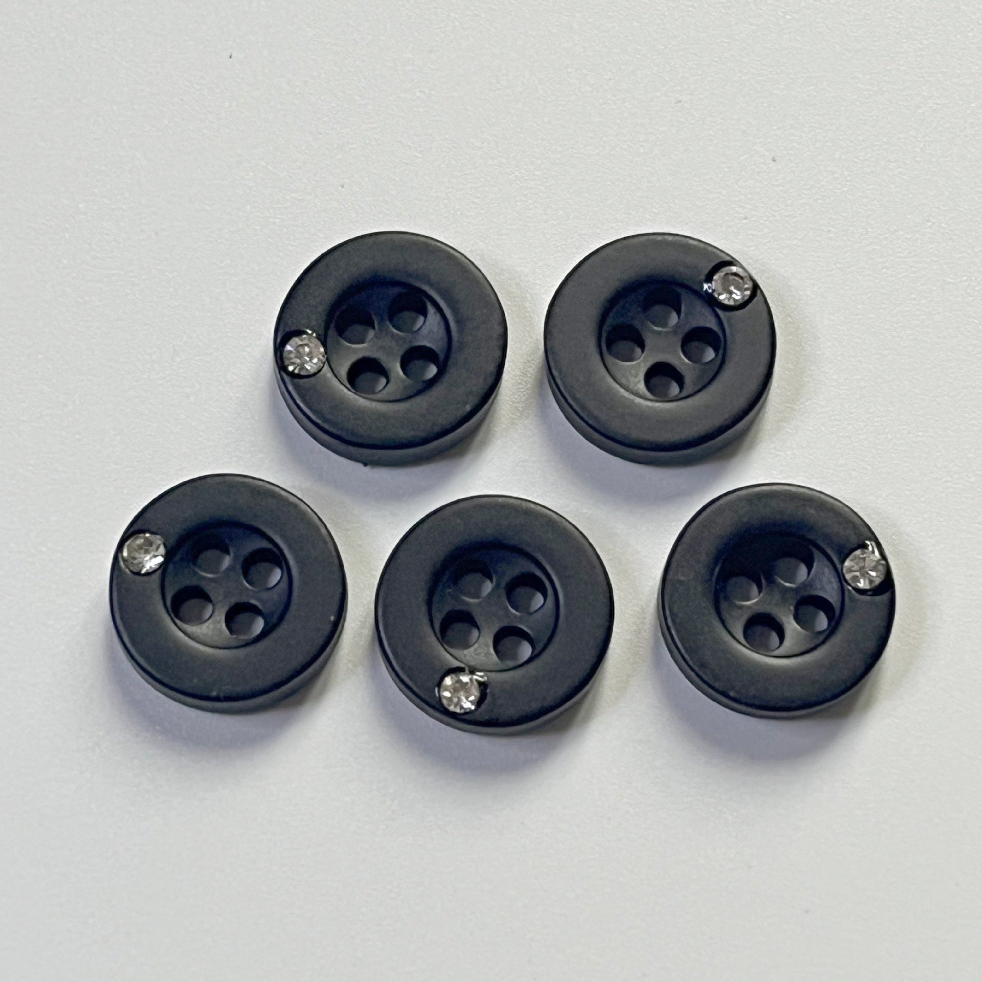 Five black 11mm round resin buttons, each with four holes and rhinestone detail
