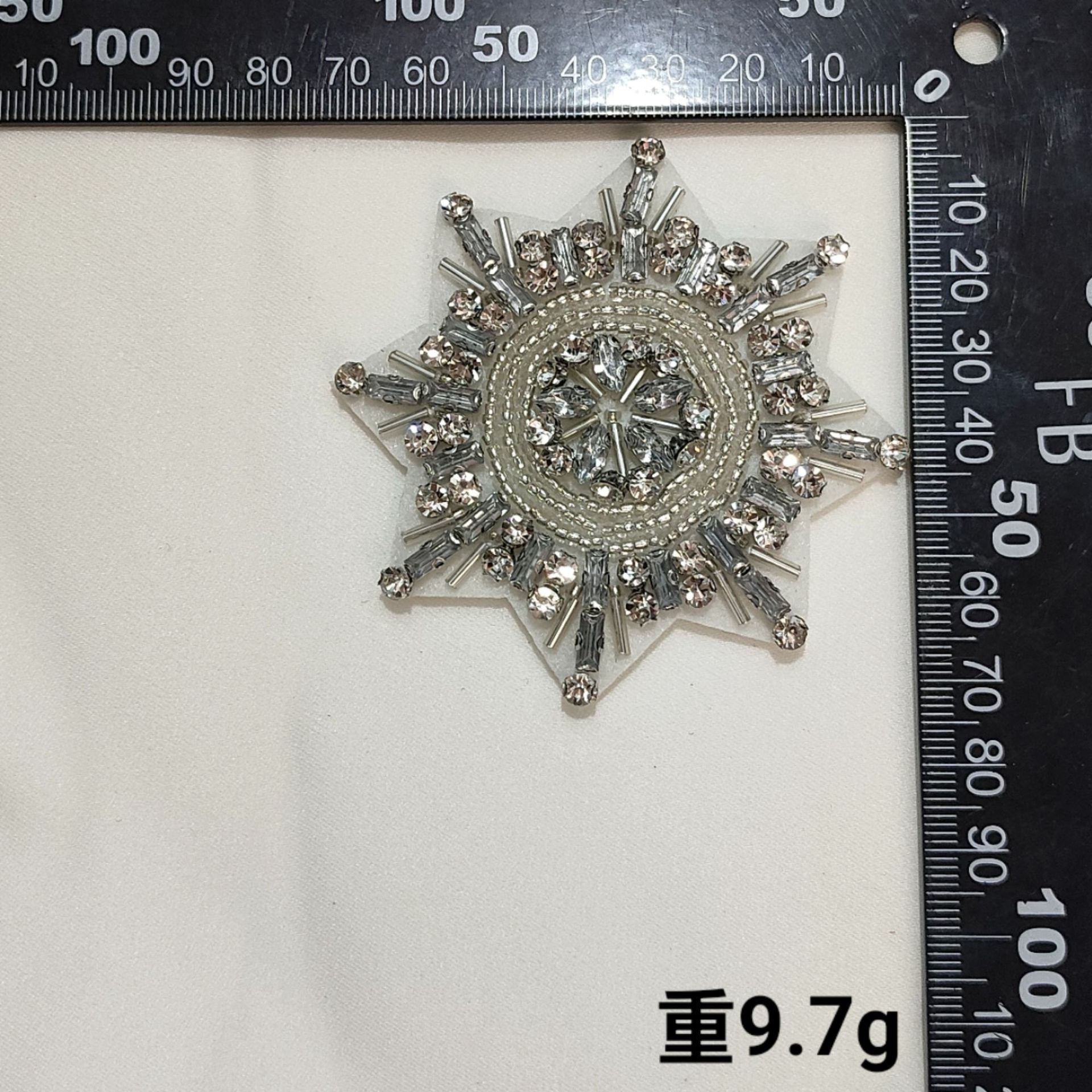 Silver-toned starburst badge patch with rhinestones and beaded center ring