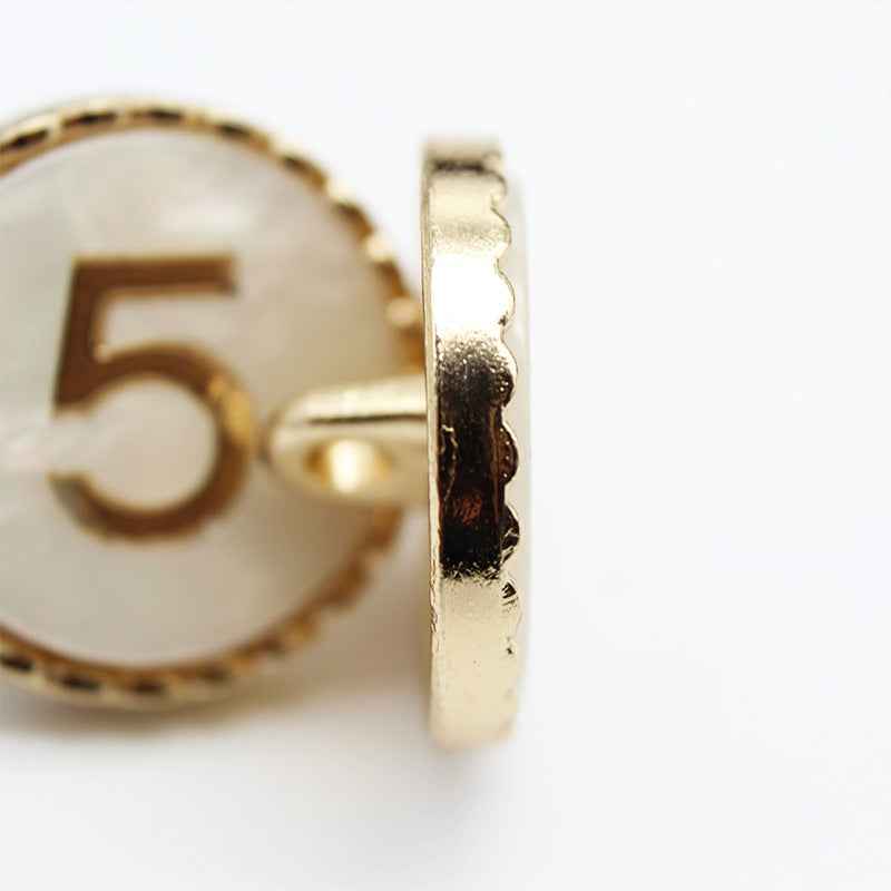 Number 5 resin shank button side view, metal shank on gold-trimmed edge