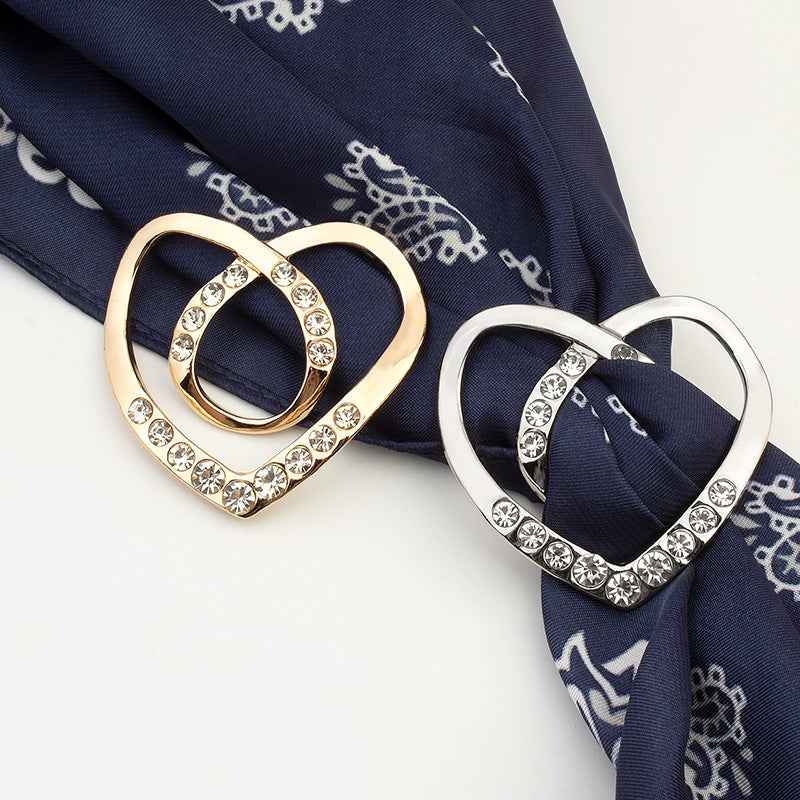 Gold and silver heart-shaped rhinestone buttons with crystal-studded edges on fabric