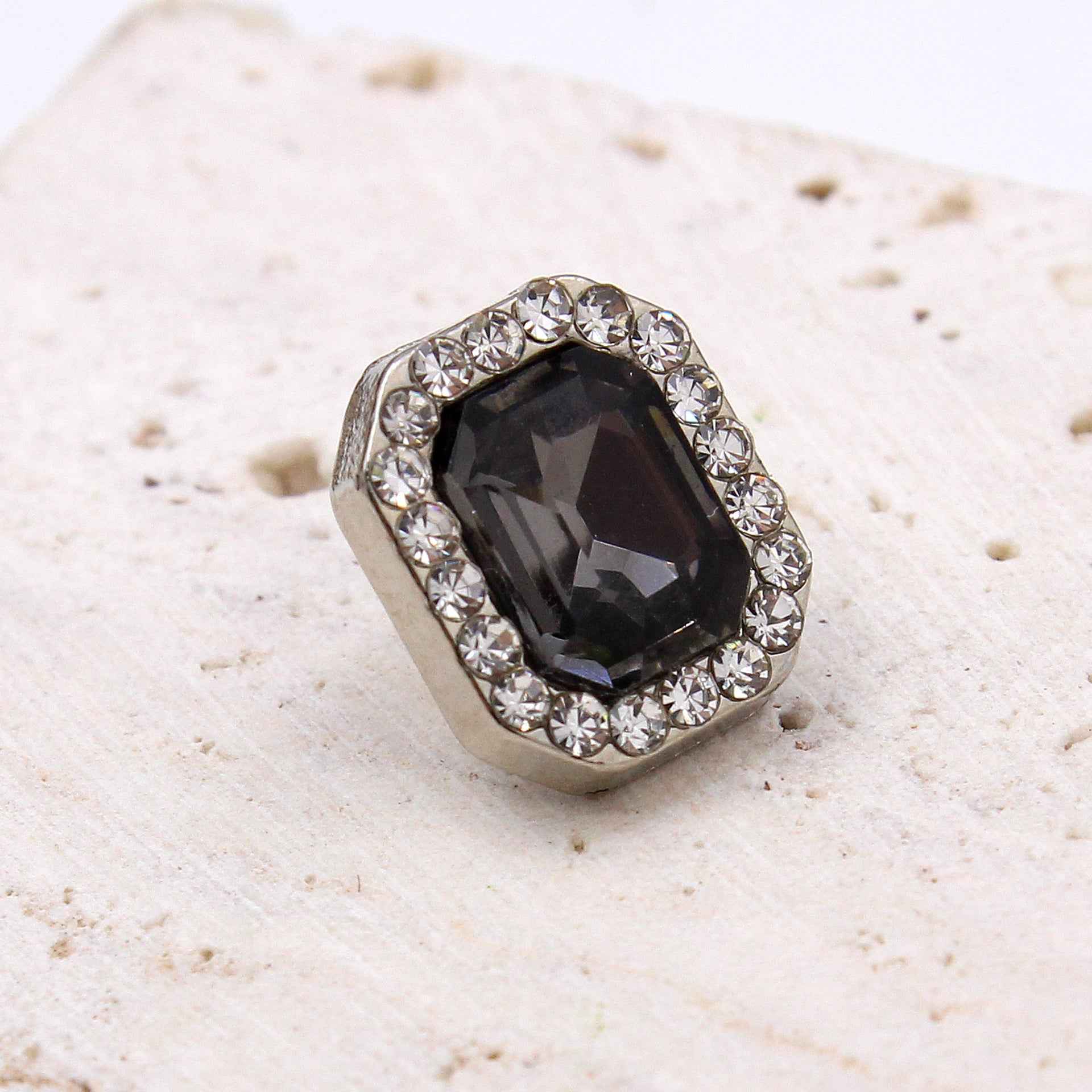 Single crystal glass rectangle button with dark faceted stone and rhinestone border