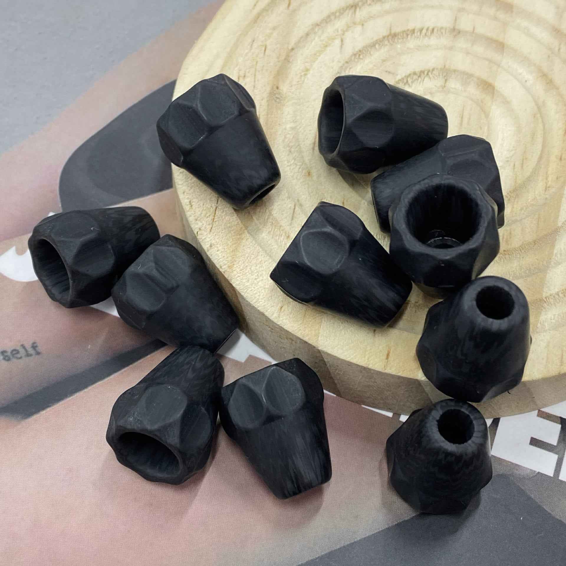 Black resin cord end stopper with round single hole and faceted bell top