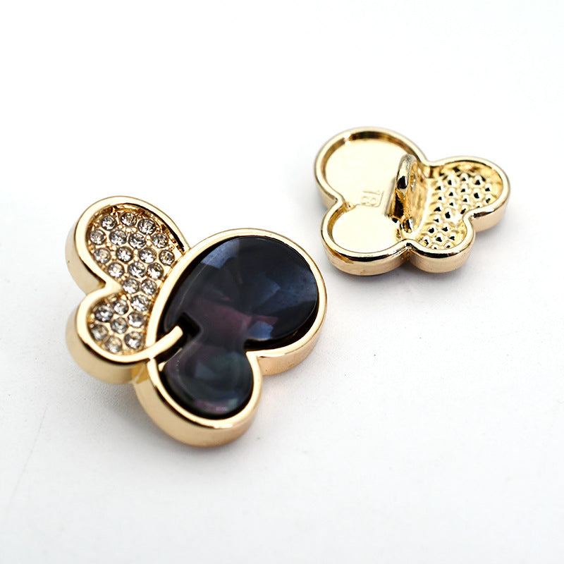 Black butterfly rhinestone shank button with gold-tone metal setting