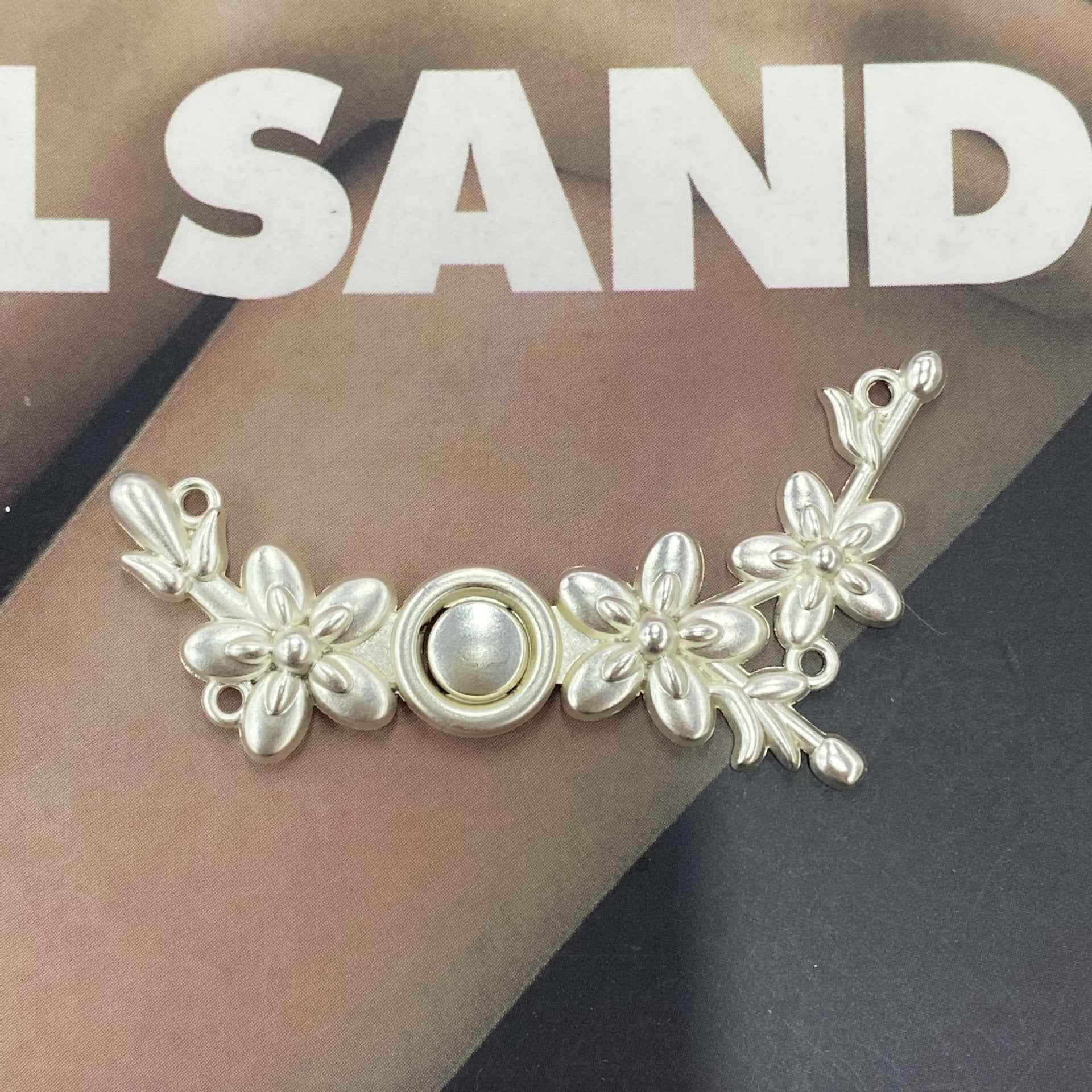 Silver-tone metal frog button (Style 4), floral vine scrollwork with central ring detail