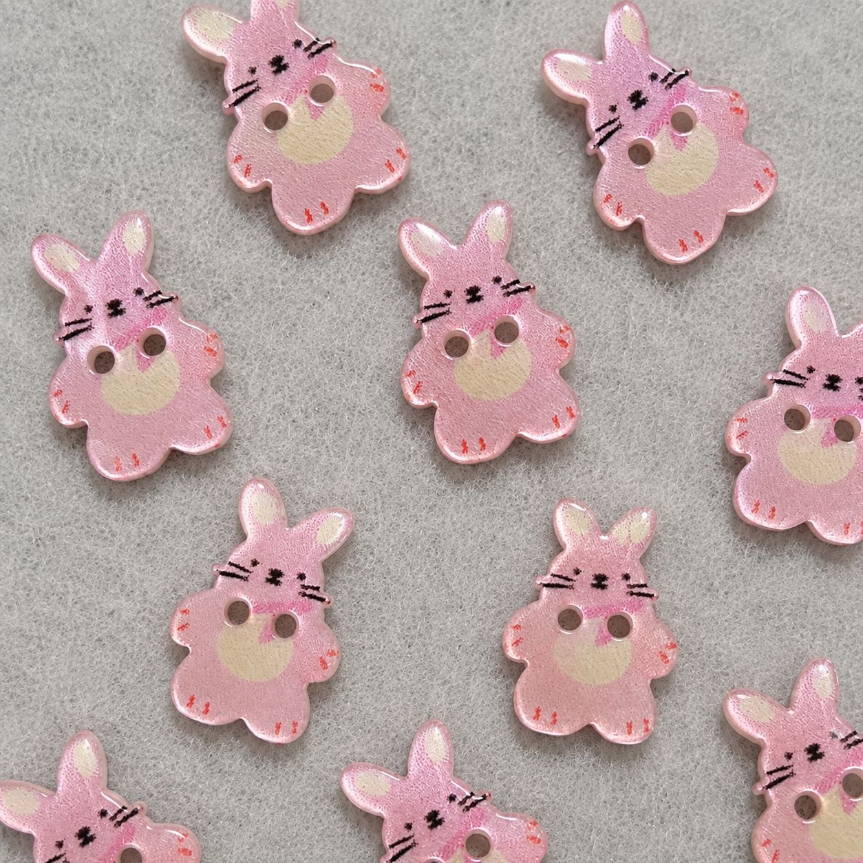 Set of pink bunny resin sew-on buttons, two-hole design with faces