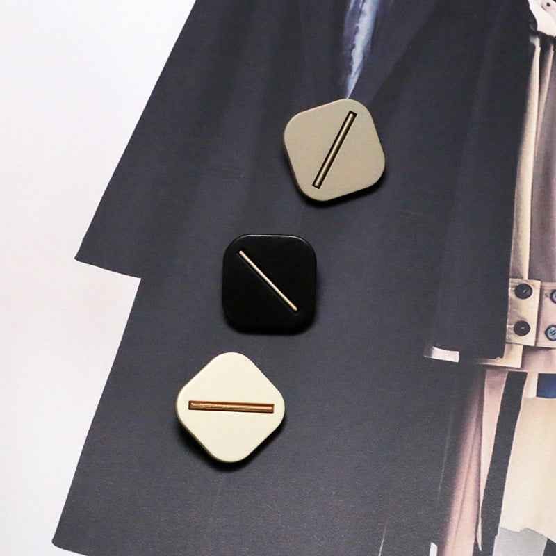 Square resin shank buttons in black and beige on garment fabric, bar slot