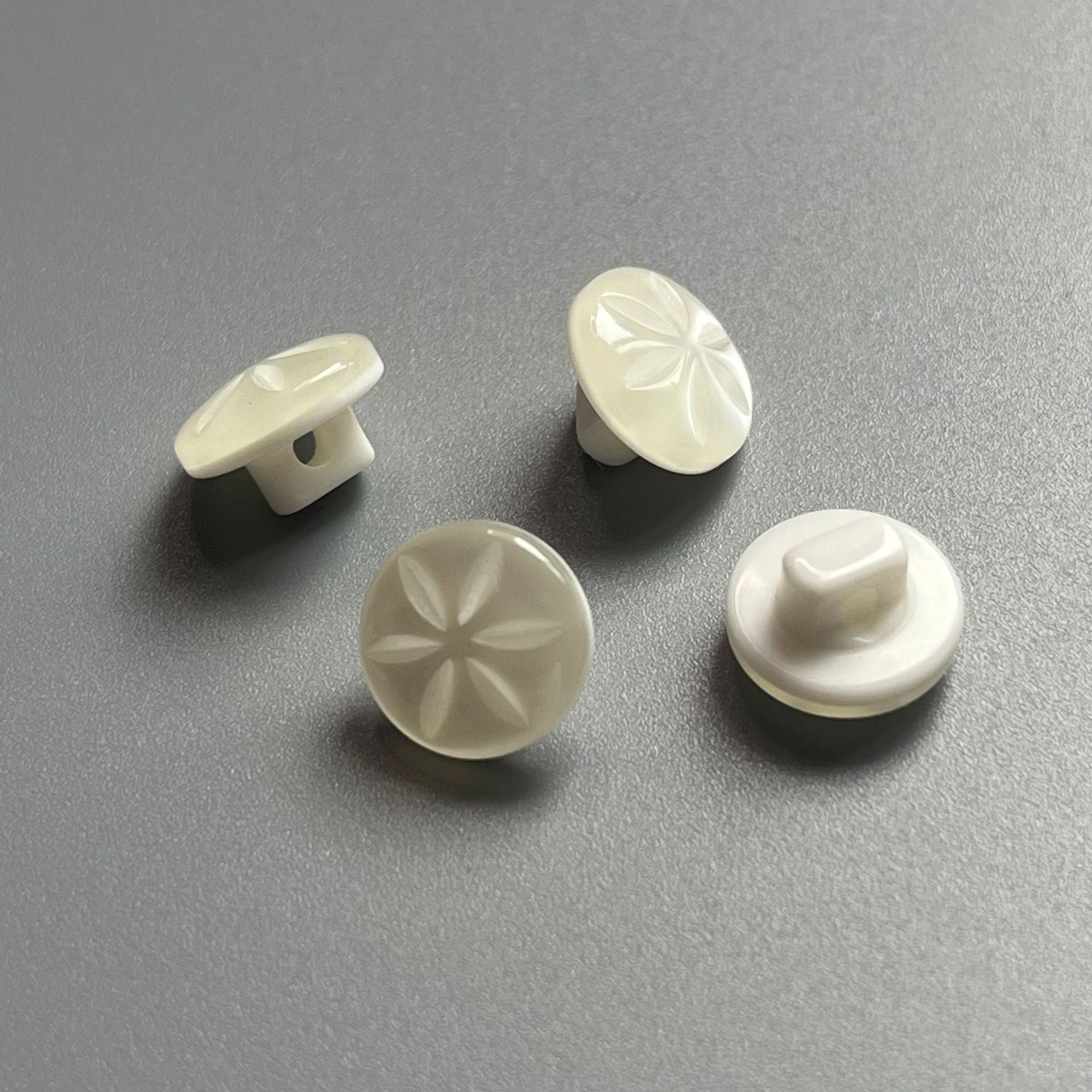 Light cream pearlized resin shank buttons with floral star relief, mixed angles