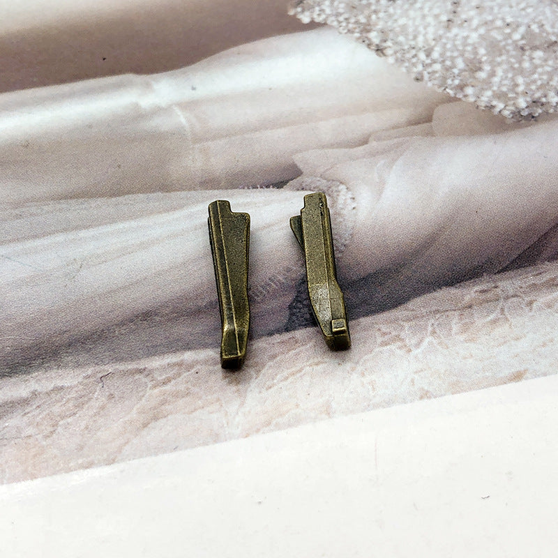 Pair of dark-bronze #5 zipper slider retainers with metal insertion pin tabs
