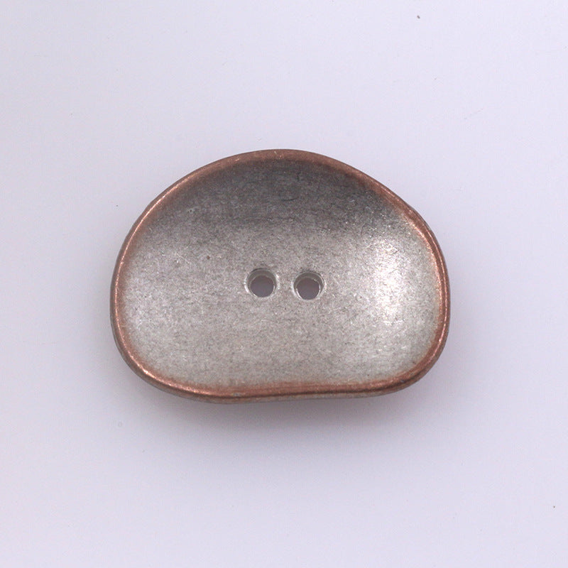 Irregular two-hole metal button, rose-gold finish, rounded oval shape