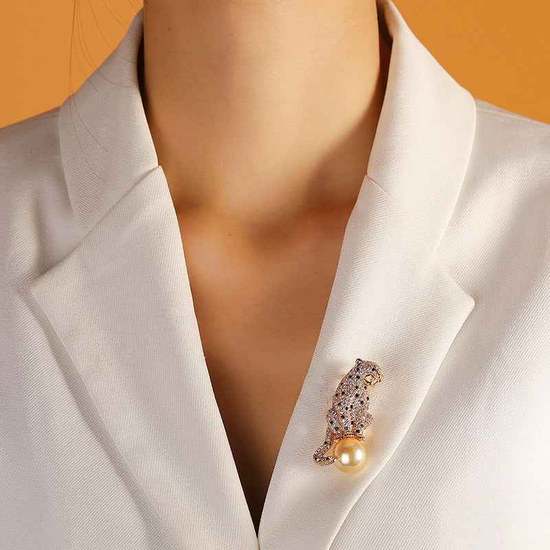 Panther brooch on a white lapel, copper zircon with yellow pearl