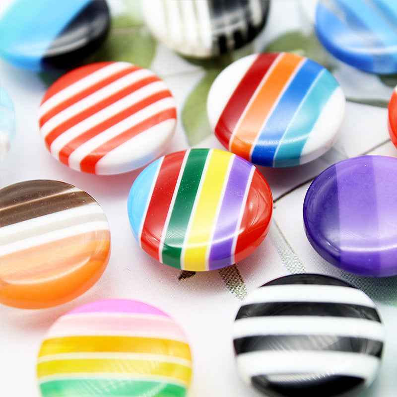 Round resin striped shirt buttons, multicolor stripes, shank backs visible in view.