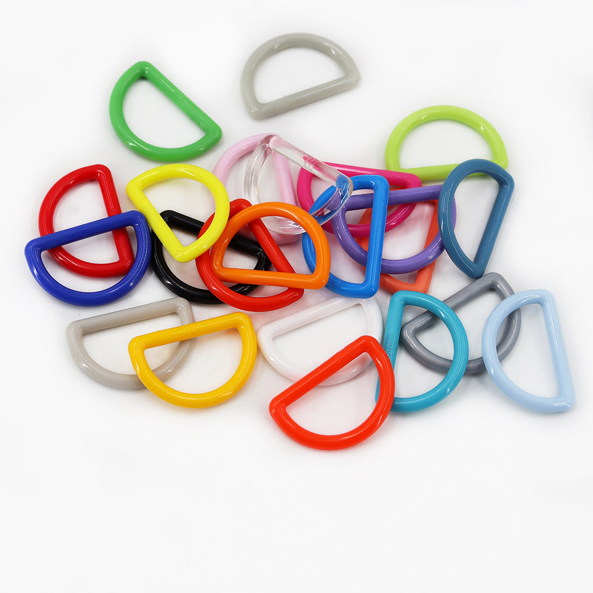 Assorted 1-inch plastic D-ring buckles for bag straps, mixed colors in a pile