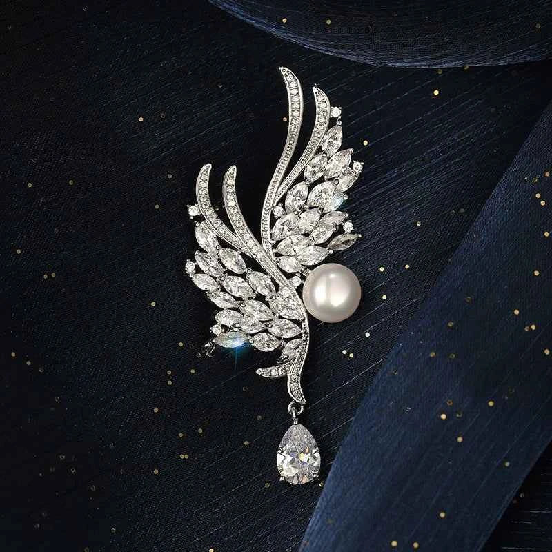 Silver wing brooch pin with white pearl center and hanging clear stone detail