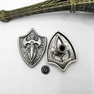 Silberne Shield-Studs mit Kreuzmotiv, Zierplatte und Nietbolzen (2 Stk sichtbar)