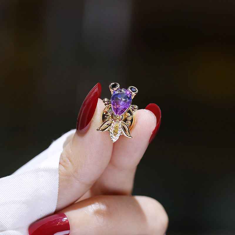 Goldfish zircon brooch pin held in hand, blue-purple crystal and gold-tone fins