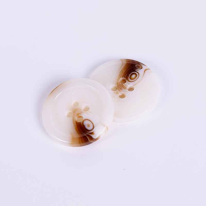 White resin coat button, round with four holes, tan-brown swirl detail
