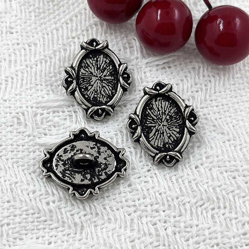 Black oval metal shank buttons with engraved floral design; worn-look metal back plates