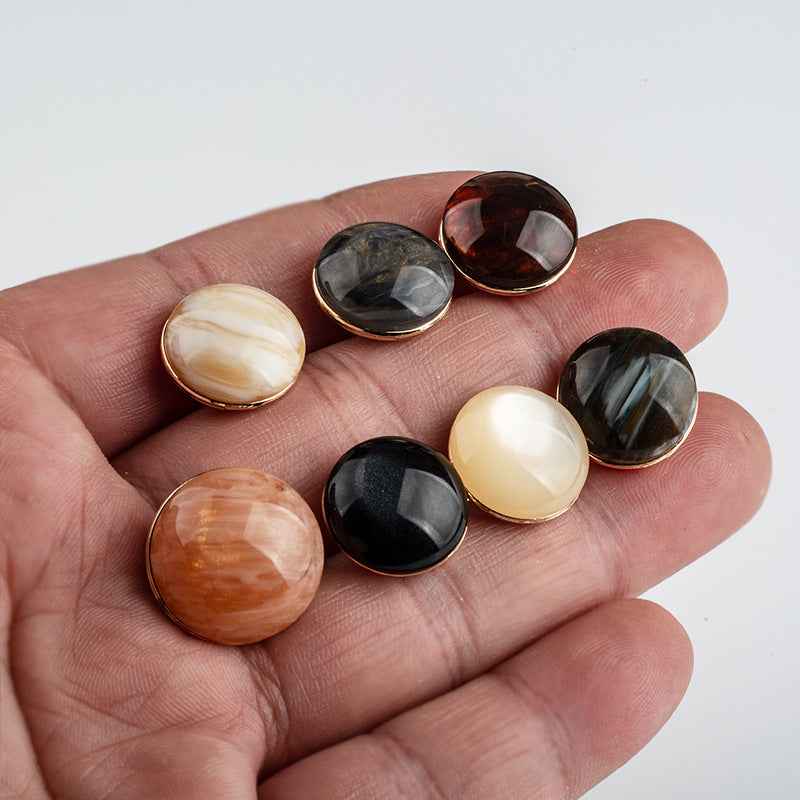 Round resin buttons with metal backing and shank on hand, mixed colors