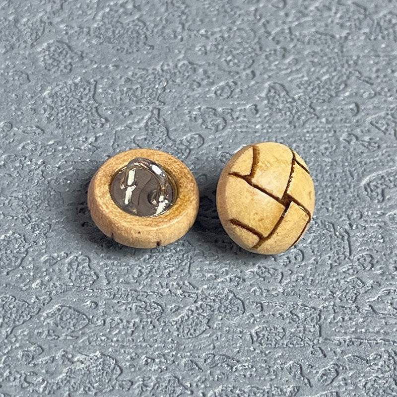 Round natural wood shank button with metal loop base, cross-engraved face