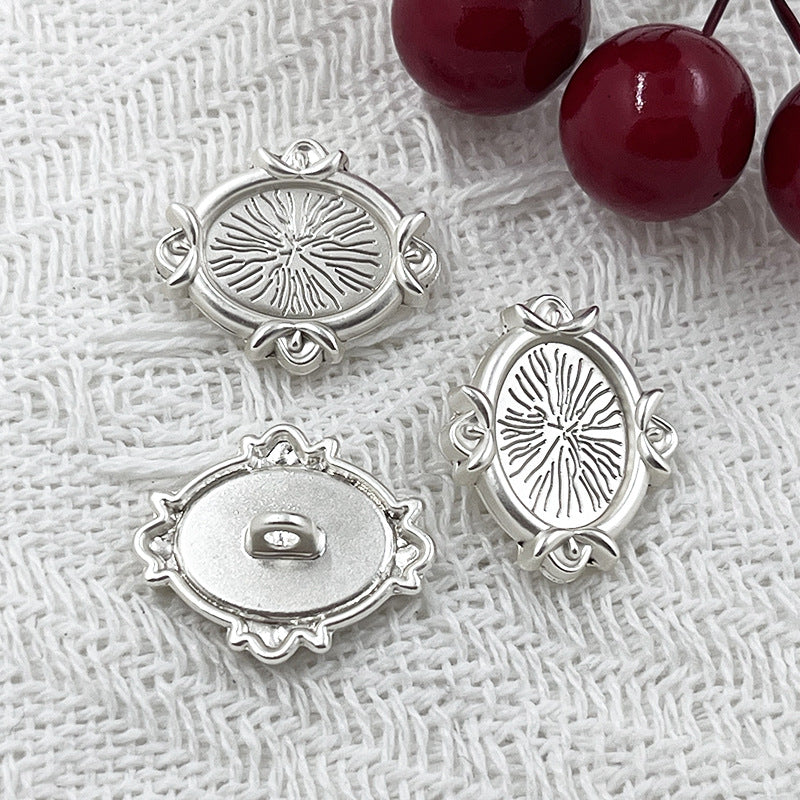 Silver oval metal shank buttons with engraved floral design; visible front and back