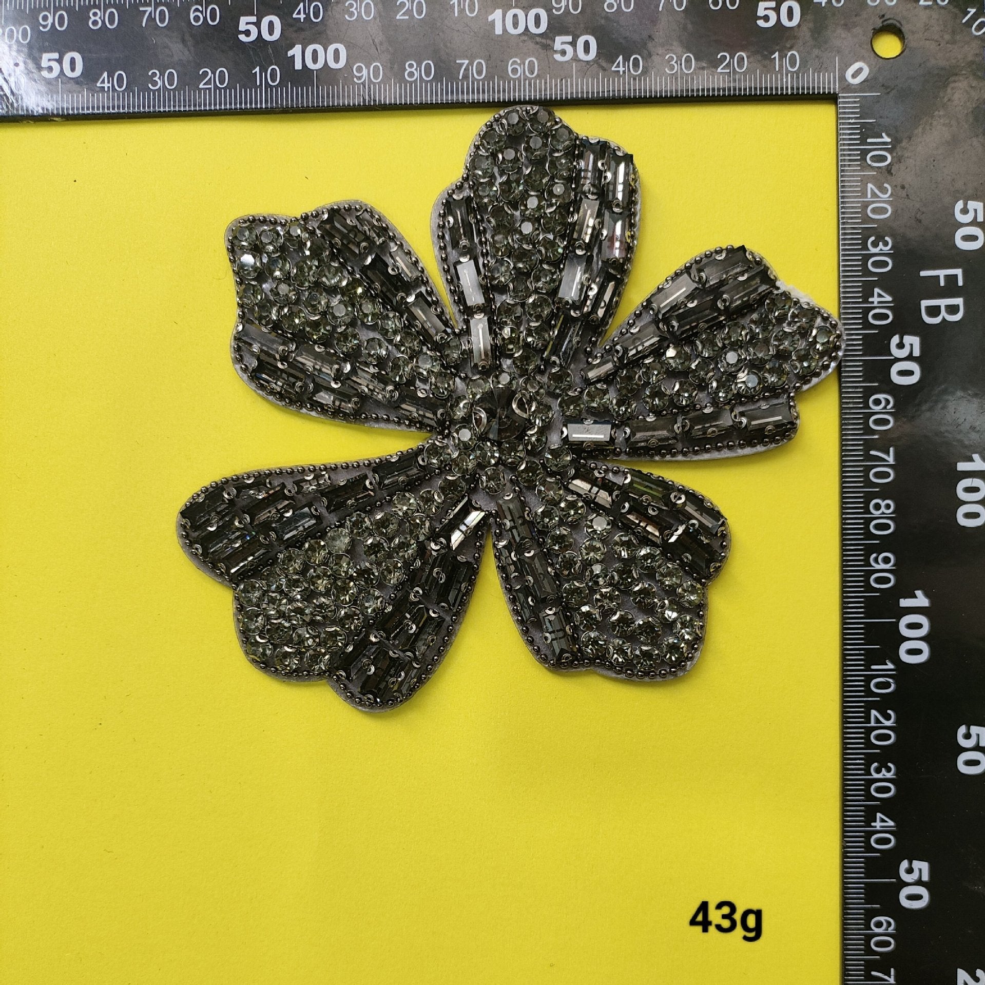 Black and silver bead flower patch with sparkling crystal rows, measured next to ruler