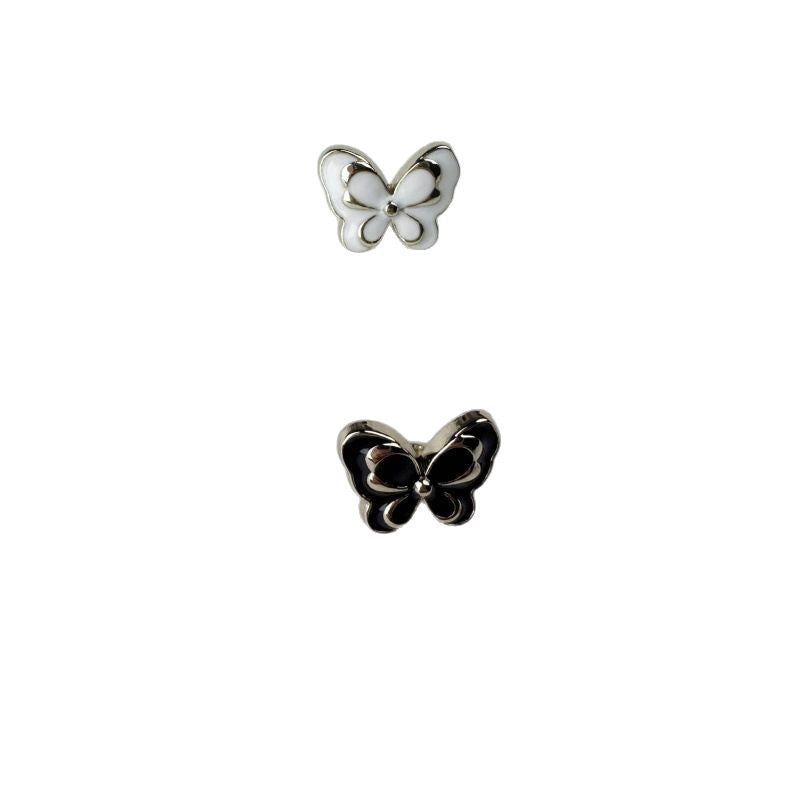 Pair of butterfly metal buttons: one white enamel, one black enamel, gold backs